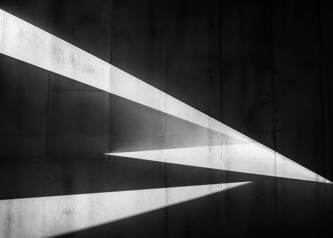 Shafts of light across a concrete wall